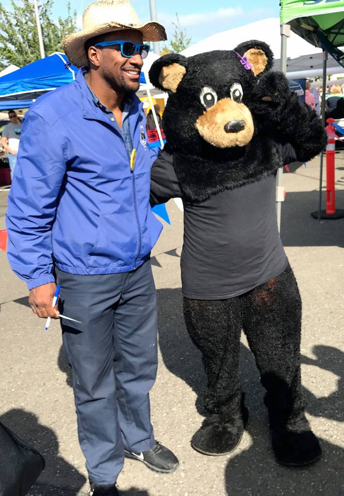 Former Seattle Seahawks player Jordan Babineaux was a guest judge at the Federal Way Farmers Market&rsquo;s Chili Cook-off. He is pictured with the mascot from Black Bear Diner. Photo by Andy Hobbs, the Mirror