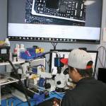 Joe Ham works on a cell phone logic board under a microscope. HEIDI SANDERS, the Mirror