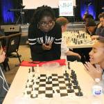 Phiona Mutesi, center, the Queen of Katwe as she is known, advises Samantha Valenzuela, left, a student at Kilo Middle School, and Tacoma Community College student Daniell Smith during a chess session at Family Life Community Church in Federal Way Wednesday. Mutesi, an international chess champion featured in the movie, Queen of Katwe, was invited by members of the church who attend Northwest University in Kirkland with her. The evening coincided with a Chess with the Superintendent session, during which Federal Way Public Schools Superintendent Tammy Campbell teaches students the basics of chess. JESSICA KELLER, the Mirror