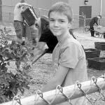 Jacob Smith pauses for a smile while clearing dead leaves at Star Lake Elementary in the Federal Way school district for National Day of Service in October. Courtesy Sheryl Mackey