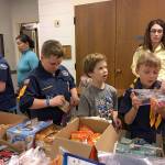 Members of the Church of Jesus Christ of Latter-day Saints Cub Scouts packs 305 and 301, led by committee chairs Dan Miller and Becky Kelly, on Dec. 12 assemble care kits for the homeless who visit the Federal Way Day Center. The care kits included hygiene items and snack food and fleece scarves the boys made. The day center relies on donations like these from the community. Contributed photo