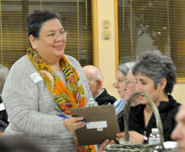 Christina Portillo, who volunteers at the Federal Way Day Center, passes around a clipboard to get more people to help at the center. Heidi Sanders, the Mirror
