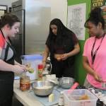 Federal Way High School sophomore Madison Smith, from left, sophomore Yeimy Reyes and senior Dora Stephenson, students in Sherry Kerrs Foundation of Culinary Arts class, measure out ingredients for holiday peanut butter blossom cookies before holiday break. Kerrs culinary arts classes are popular among students who are taking an elective or planning a career in the restaurant or food service industry. JESSICA KELLER, the Mirror