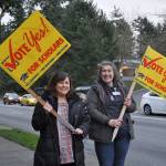 Kristi White, left, and Marissa Harvey wave signs late Tuesday afternoon at the corner of South 320th Street and First Avenue South encouraging residents to vote yes for the Federal Way Public Schools levy. Heidi Sanders, the Mirror