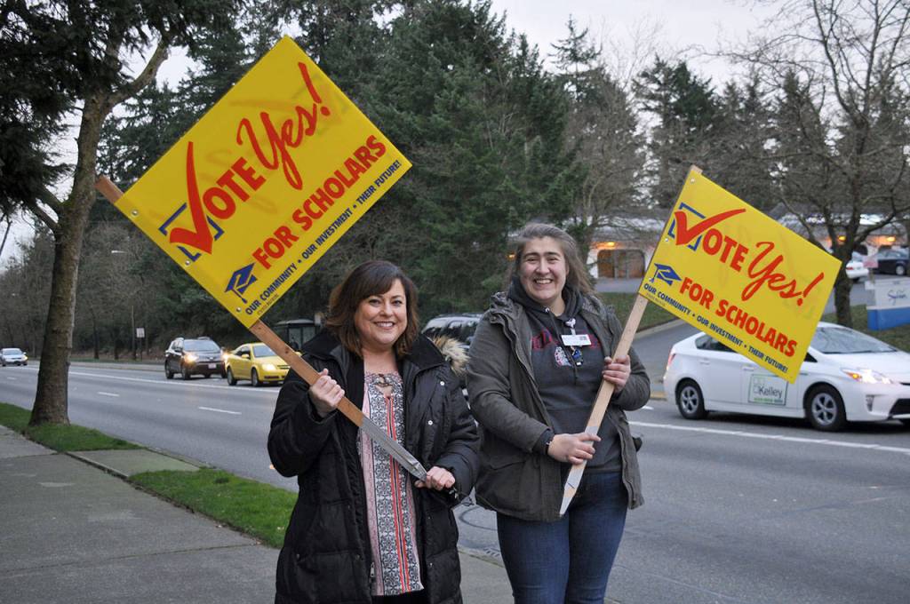 Kristi White, left, and Marissa Harvey wave signs late Tuesday afternoon at the corner of South 320th Street and First Avenue South encouraging residents to vote yes for the Federal Way Public Schools levy. Heidi Sanders, the Mirror