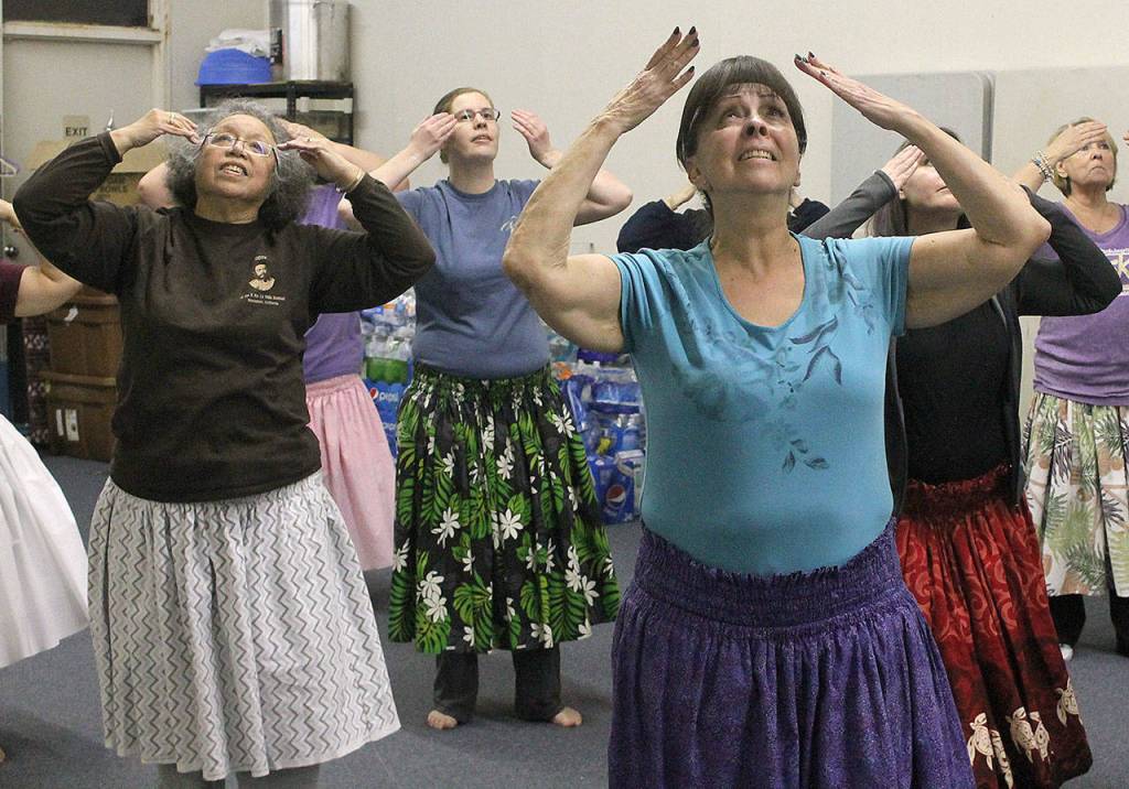 TIsh Pinho, right, and Cynthia Mann, left, perform an ancient Hawaiian dance with other members of the Federal Way hula school at a practice. The hulaus kumu, or teacher, Kamaile Hamada not only teaches ancient and modern hula dances, he also teaches other aspects of the Hawaiian culture at his school. JESSICA KELLER, the Mirror