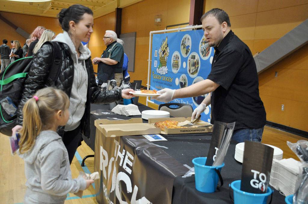 Jason Johnson, general manager of The Rock Wood Fired Pizza in Federal Way, hands out slices of pizza during the event. Heidi Sanders, the Mirror