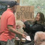 Federal Way resident Anne Hatch holds a sign urging city officials to cut spending rather than impose a 7.75 percent excise tax on water and sewer utilities in Federal Way at Tuesday nights City Council meeting. Despite the protests and pleas of a large number of residents who spoke, the City Council voted 5-2 to impose the tax. JESSICA KELLER, the Mirror