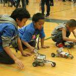 Lake Grove Elementary second-grader Josiah Taala, from left, and Nautilus kindergartner Zephaniah Taamu race robot drag race cars built by TAF@Saghalie students while Titan Ili, 4, gets his ready to race at the STEM Exploration Night Wednesday, March 28, at Todd Beamer High School. Jessica Keller, the Mirror