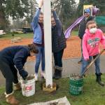 From left, Mia Rapp, Alyssa Cleveland, Hanna Banks and Halle Banks mix cement and stabilize the pole for the book house. Courtesy Catherine Banks                                From left, Mia Rapp, Alyssa Cleveland, Hanna Banks and Halle Banks mix cement and stabilize the pole for the book house. Courtesy Catherine Banks