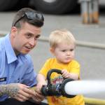 A student from the Bates Technical College Fire Recruit Academy helps a young boy spray a fire hose during South King Fire & Rescues open house on May 17 at Station 62. About 900 people attended the open house, which included demonstrations, hands-on activities, fire trucks, police cars and dogs. Courtesy Shelley Pauls