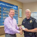 Federal Way Police Deputy Chief Steve Neal, right, accepts a donation of Wild Waves tickets for the Positive Ticket Program from Wild Waves General Manager Todd Suchan. Courtesy FWPD