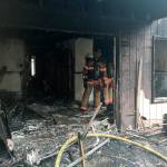 Firefighters sift through ashes, damage after a fire burns four apartment units. Olivia Sullivan/staff photo