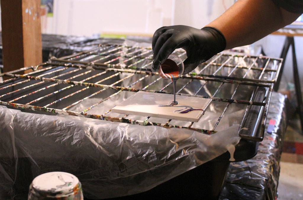 Darlene LeMaster demonstrates the paint pouring after mixing blue, purple, and copper colors together. Olivia Sullivan/staff photo