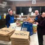 Mayor Jim Ferrell, left, Bob Roegner, and Carrie Rodriguez prepare dinner to serve at an overnight mens shelter in Federal Way. Olivia Sullivan/staff photo