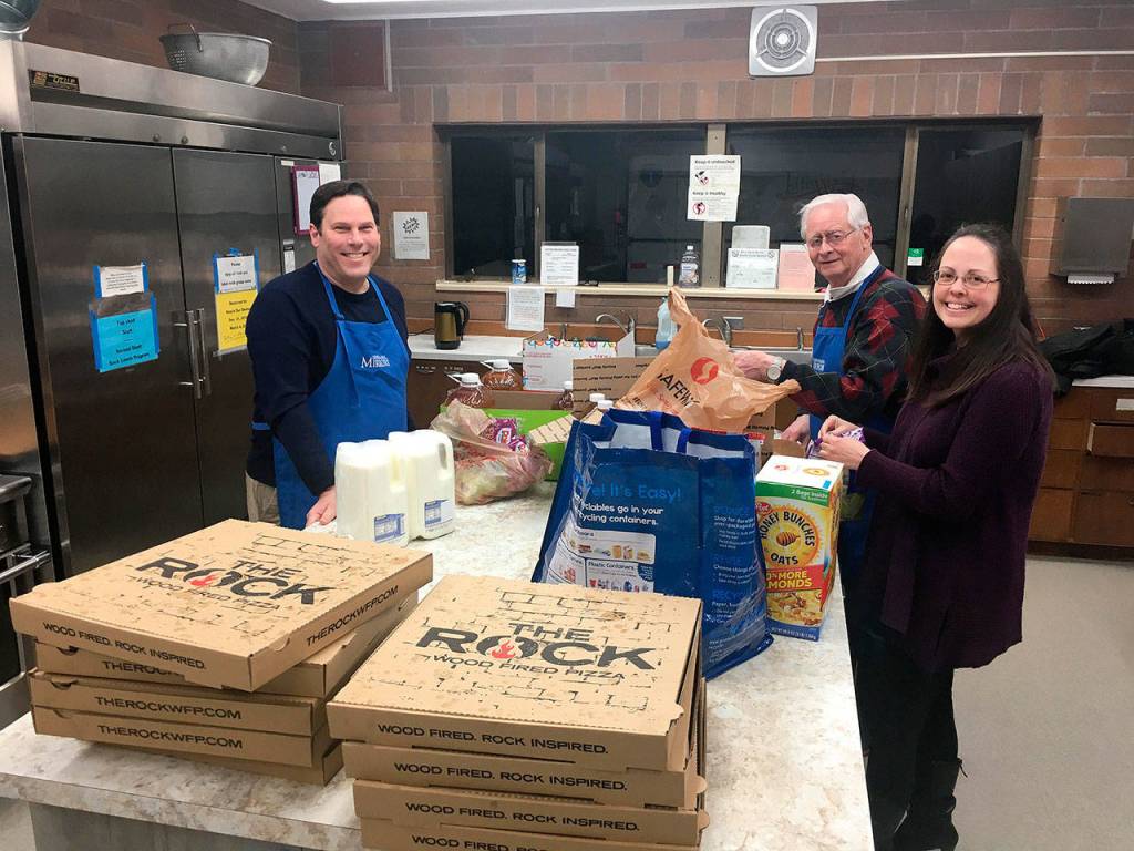 Mayor Jim Ferrell, left, Bob Roegner, and Carrie Rodriguez prepare dinner to serve at an overnight mens shelter in Federal Way. Olivia Sullivan/staff photo