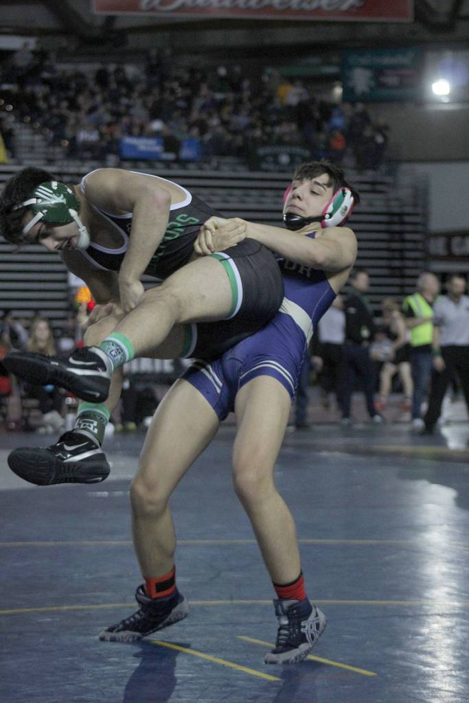 Decatur senior Cristian Torres manhandles Kentwoods Amit Jouhal. Jouhal went on to win the match by 9-2 decision. Olivia Sullivan/staff photo