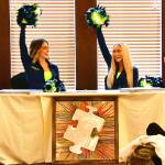 Two of the Sea Gals also attended the event to show support, meeting fans and signing posters. The art piece in front was auctioned off for more than $200. Photo courtesy of Bruce Honda