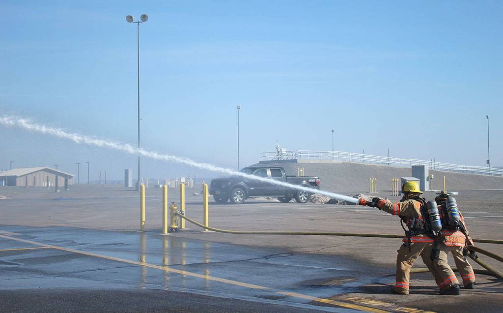 Mirror reporter Olivia Sullivan, front, and SKFR firefighter Jacob Czekanski wrangle a fully charged hose at Fire Ops 101. Photo courtesy of Craig Soucy