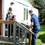 Rocio Barco (left) and SKFR PIO Brad Chaney (right) lift Bernardo Barco in his wheelchair into their non-wheelchair-accessible Des Moines home after his December 2018 motorcycle accident left him without a right arm and left leg. Haley Donwerth/ staff photo.