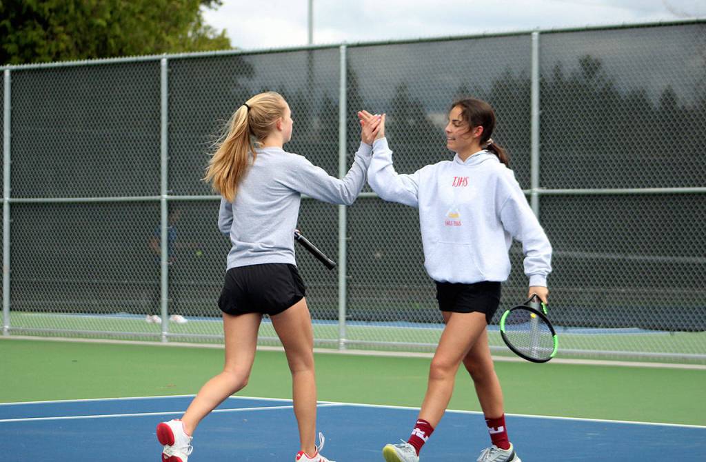 TJHS No. 1 doubles partners Ally Peterson, left, and Mia Rosa high-five after a score. Olivia Sullivan/staff photo