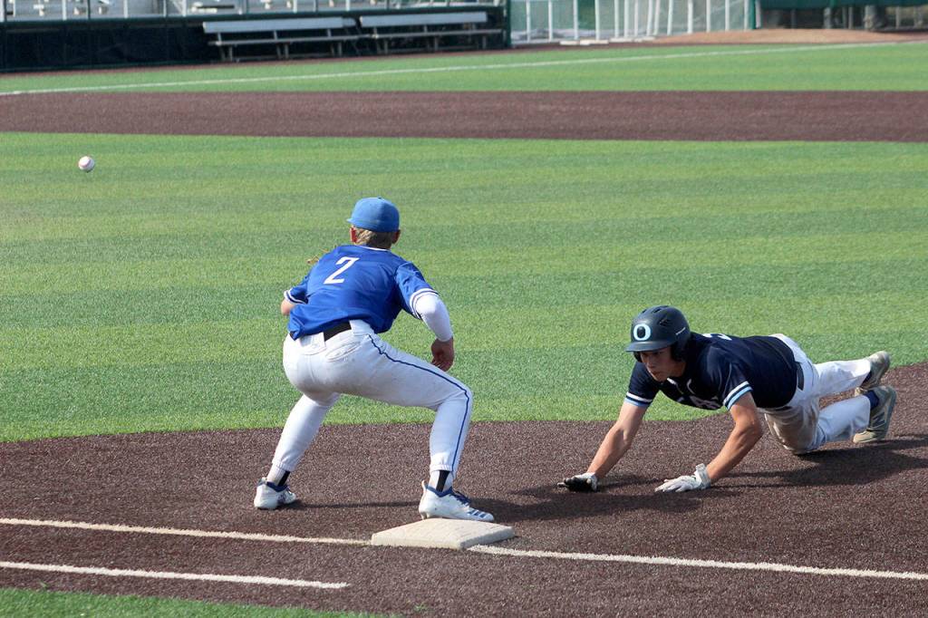Federal Ways Jack Arsenian anticipates the ball as an Olympia player leaps back to first base. Olivia Sullivan/staff photo