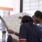 Rochelle Wilson, left, and Tyeisha Taylor admire a poster decorated with quotes and pictures of Cameron Wilson. Olivia Sullivan/staff photo