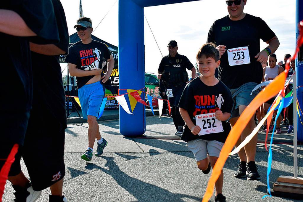 A little boy starts the Run with a Cop with a smile on his face. Haley Donwerth/staff photo