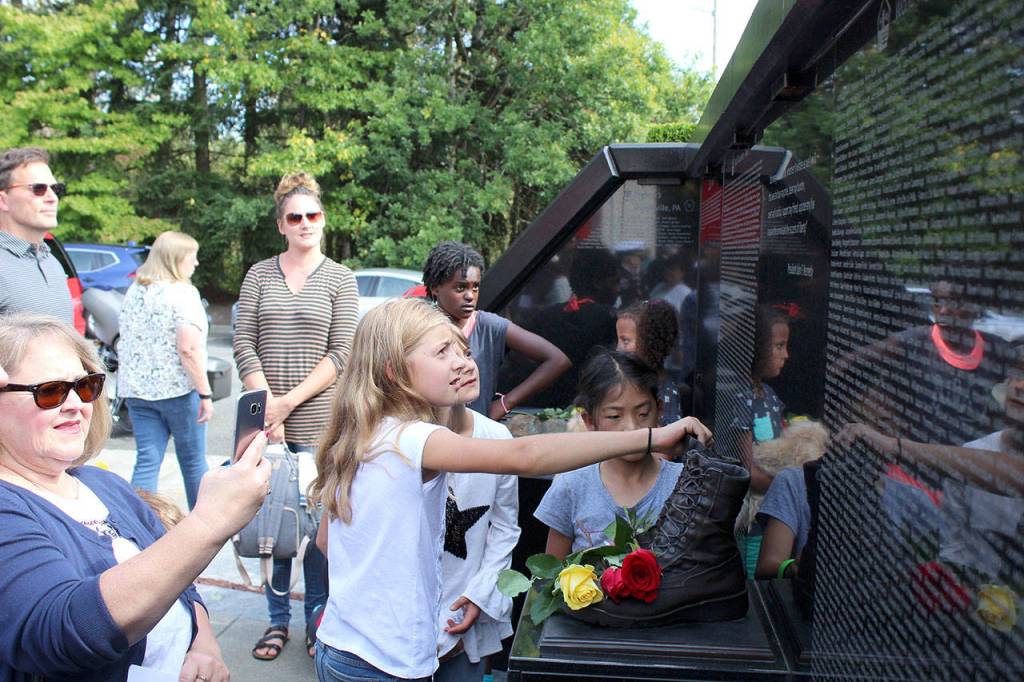 A girl touches a part of South King Fire and Rescues memorial honoring those who lost their lives on 9/11. Olivia Sullivan/staff photo