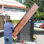 A person prays before a 10-foot steel beam from the wreckage of the World Trade Center in New York, which is part of the South King Fire and Rescues memorial honoring the lives lost in the Sept. 11, 2001 terrorist attacks. Olivia Sullivan/staff photo