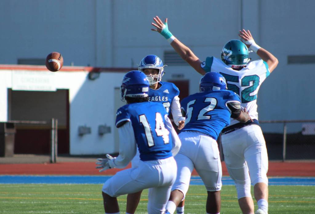 Federal Way quarterback R.J. Tausili tries to flip the ball to Calson Tiweyang as Auburn Riversides Cade Foster applies pressure during first-half action. Olivia Sullivan/staff photo