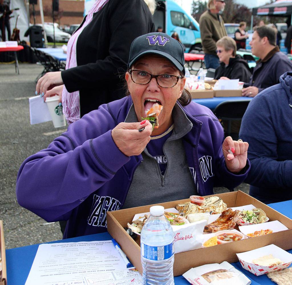 Taste of Federal Way judge Jan Novak takes a bite of her first sample dish at Saturdays event.