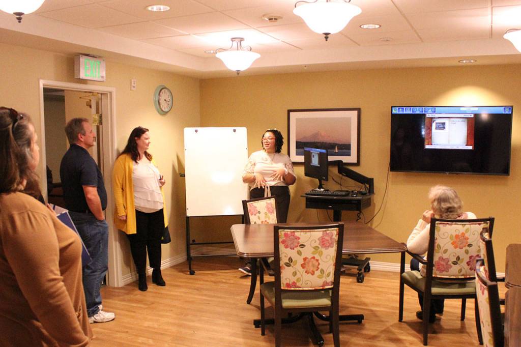 Program coordinator Angel Johnson explains Clare Bridges InTouch Technology to ribbon cutting attendees. Olivia Sullivan/staff photo