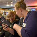 Leah Naccarato (right), a member of the 30th District Democrats, checks election night results with community members. Haley Donwerth/staff photo