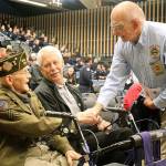 John Plumlee, who served in the U.S. Army Air Corps during World War II, shakes hands with South King Fire and Rescue Commissioner Bill Fuller at the Nov. 11, 2017 Honoring Our Own Veterans Day observance. Plumlee is seated next to his son, Ed Plumlee, retired deputy fire chief. File photo