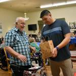 A Federal Way Vet Center employee gives a blanket and gift bag to one of the veterans living at Brookdale during their Veterans Day celebration. Haley Donwerth/staff photo