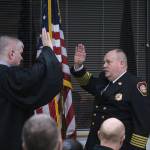 South King Fire and Rescue Chief Vic Pennington raises his right hand as he takes his Oath of Office on Friday, Dec. 27 at the monthly board of fire commissioners meeting, sworn in by Judge Dave Larson. Penningtons swearing in ceremony was followed by a thunderous and lengthy applause from meeting attendees including fire department staff, board commissioners, Des Moines City Council members and family members. Olivia Sullivan/staff photo