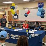 Decatur softball head coach Mike David shares the success of seniors Maclairen Magruder, left, Jenna Bettge, middle, and Ainsley Yoshizumi, right, at the players National Letter of Intent signing on Jan. 17. Olivia Sullivan/staff photo
