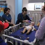 A Highline College student demonstrates using a breathing apparatus on a simulation patient to a grand opening tour group on Jan. 31. Olivia Sullivan/staff photo