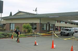 A security guard positions cones as he stands watch in front of the Econo Lodge-turned-coronavirus-quarantine site on Central Avenue North on Tuesday. King County personnel were on site preparing the motels transformation into an isolation/quarantine center. MARK KLAAS, Kent Reporter
