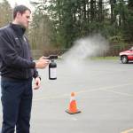 Firefighter James Hampson demonstrates the atomizing sprayer used to disinfect an officers weapons, body armor or other equipment. Olivia Sullivan/staff photo