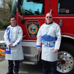 Firefighter Brett Connelly, left, and Driver Engineer Jim Wilson wear the handmade protective gowns, sewn by Wilson with materials donated from Lowes Home Improvement store in Federal Way. Olivia Sullivan/staff photo
