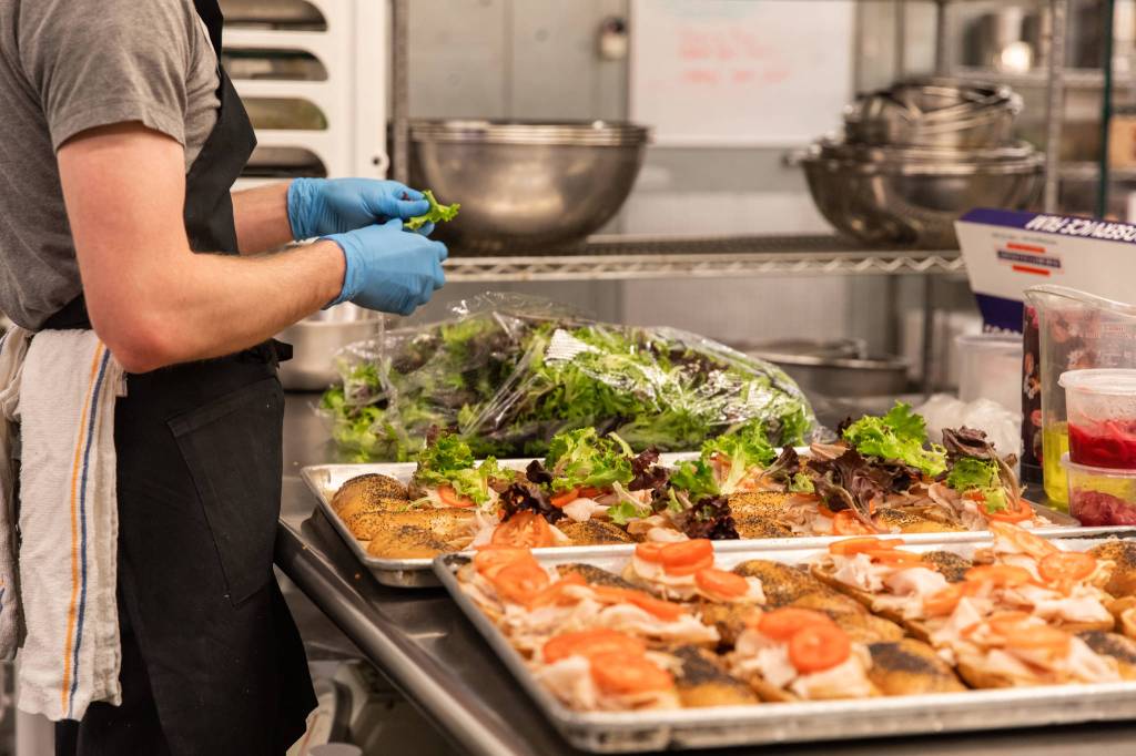 James Gasser with Lisa Dupar Catering prepares sandwiches, part of the boxed lunches that will be delivered to first responders working at COVID-19 testing sites. Photo courtesy of Hannah Sheil