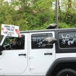 Kathy Alden drives by the Alder Ridge Senior Apartments on May 2 with a sign that reads: Hang in there, we miss you. Olivia Sullivan/staff photo