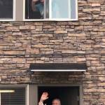 Residents of Alder Ridge Senior Apartments wave from their doorstep and window during the parade on May 2. Olivia Sullivan/staff photo
