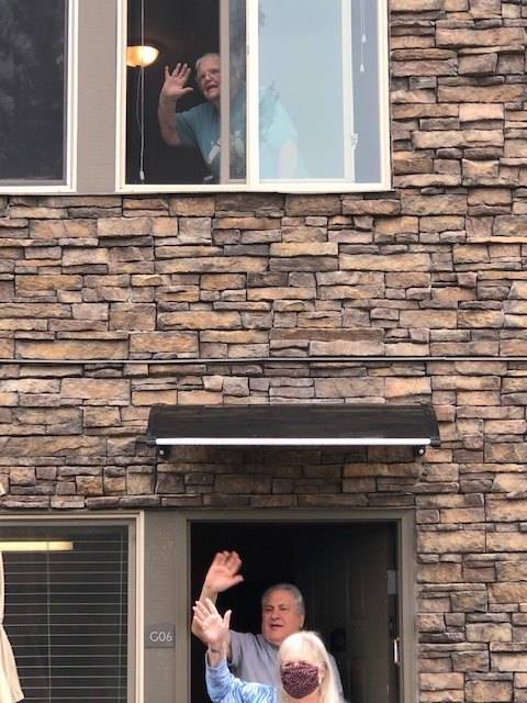 Residents of Alder Ridge Senior Apartments wave from their doorstep and window during the parade on May 2. Olivia Sullivan/staff photo