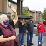 Doreen Davis, left in mask, waves at the parade participants with fellow residents on May 2. Olivia Sullivan/staff photo