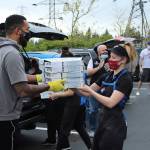 A Dominos employee hands a stack of pizzas to Federal Way leader Keenan Curran on May 4. Olivia Sullivan/staff photo