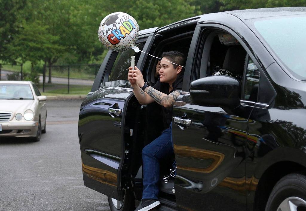A family member leans out of the car to snap a photo of a Todd Beamer High School senior at the FWPS virtual graduation walk recording on May 20. Olivia Sullivan/staff photo