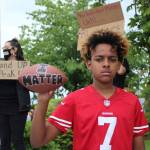 12-year-old Doni Burkett holds a football reading I Matter while wearing a Collin Kaepernick jersey on Sunday, May 31 in Federal Way. Olivia Sullivan/staff photo